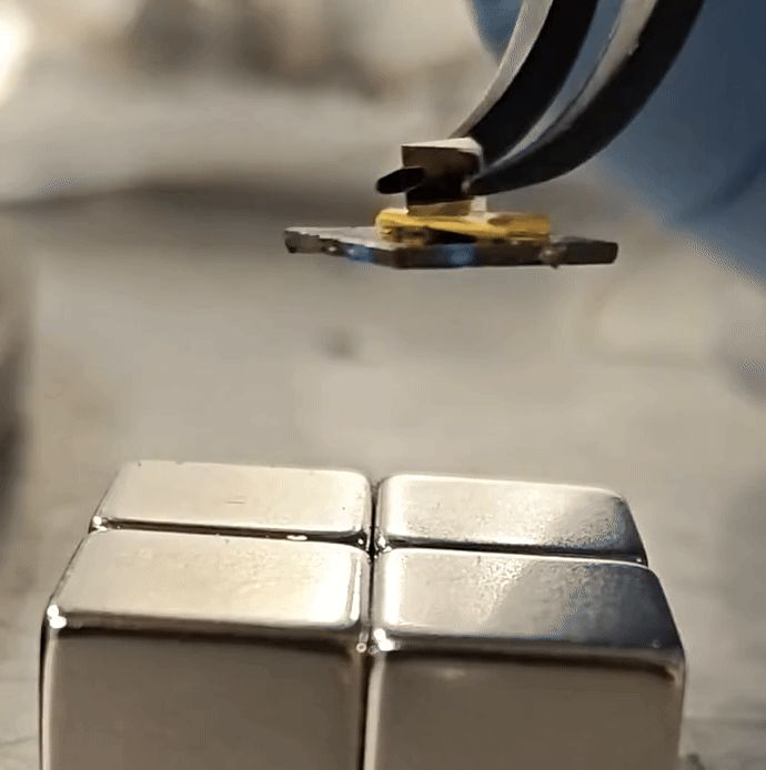 Close view of an optical mount being placed above permanent magnets